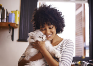 A happy person enjoying a cuddle with their cat