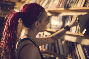 Young student choosing a book from bookshelf in a library