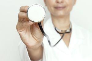 A doctor holds out a stethoscope